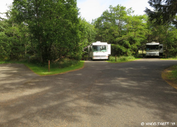 View down partial hookup ring. Empty site #69 on left with #68, #67 behind.