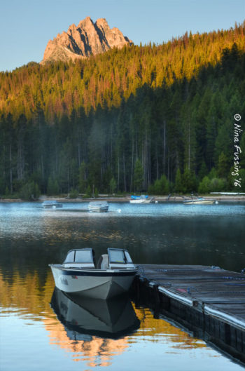 A boat rocks in early morning glow by Redfish Lodge