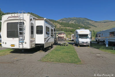 View from the row behind us. Site #5 on right, #4 on left. The slice of green is shared sitting space. You can *just* see our RV in back #41.