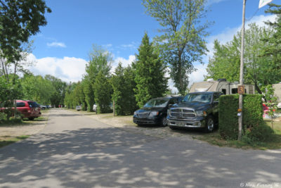 View down central "row section" of campground. This is row 3 viewed from the front (water-side) end. Site #1076 on right with #1075 behind it.