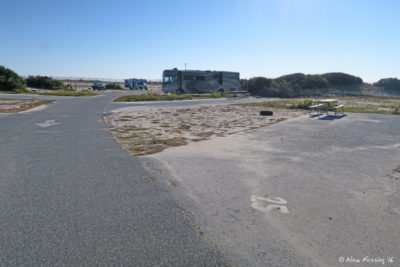 View down E loop. Empty site E25 on right with RV in E21 two sites behind it.